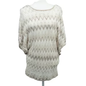 A picture of a sweater that is white, tan, cream colored in a zig zag chevron pattern. It has short sleeves and a long body.