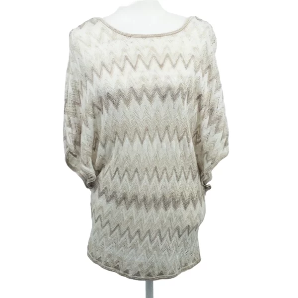 A picture of a sweater that is white, tan, cream colored in a zig zag chevron pattern. It has short sleeves and a long body.